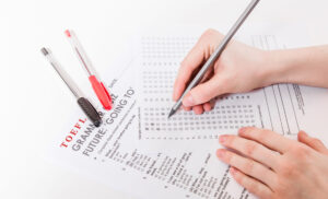 Test d'inglese a risposta multipla su tavolo. Donna mentre fa il test