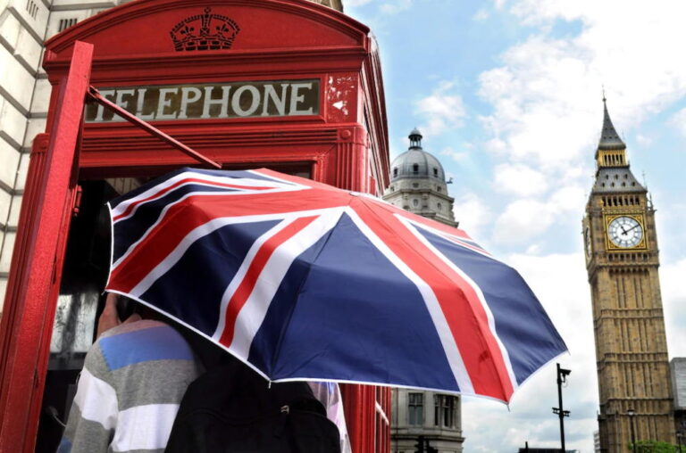 Ragazzi che camminano per Londra con un ombrello con la bandiera inglese