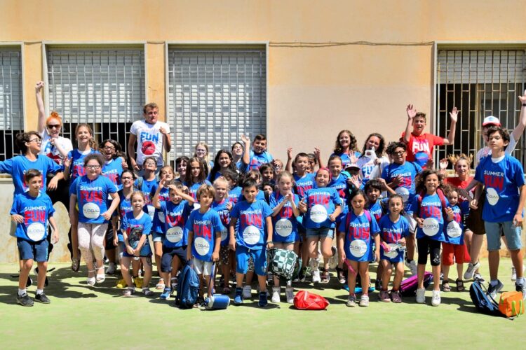 Gruppo di ragazzi in un campetto all'aperto insieme ai loro educatori